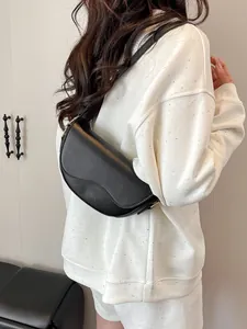 Chic black PU leather saddle bag for women with an adjustable strap and gold buckle detail