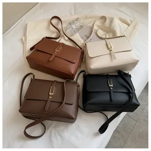 Detailed view of structured leather crossbody bags in four colors with gold buckle accents