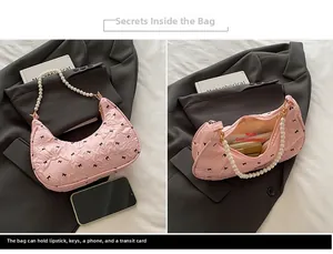 Internal details of pink bow embroidered bag with pearl strap and main pocket view
