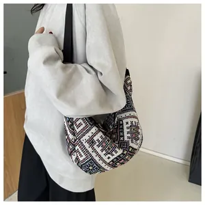 Close-up of ethnic geometric pattern crossbody bag with adjustable black canvas strap