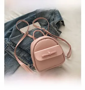 Detailed comparison of pink mini bow backpack size with a smartphone for scale