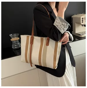 Detail showing high-quality vertical striped canvas tote bag with leather straps for daily use
