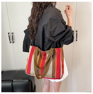 Makroaufnahme der gestreiften Canvas-Tasche mit texturiertem Stoff und breitem Schultergurt
