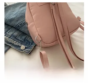 Detailed close-up of pink mini backpack featuring durable metal D-rings and detachable straps