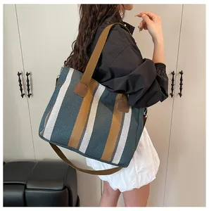 Detailansicht eines großen gestreiften Canvas-Shoppers mit breitem Gurt und Lederpatch