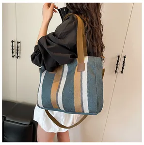 Detailaufnahme der gestreiften Canvas-Tasche mit verstärktem Lederriemen und Metallring