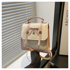 Close-up of pink bow and heart pendant on white faux leather fashion backpack