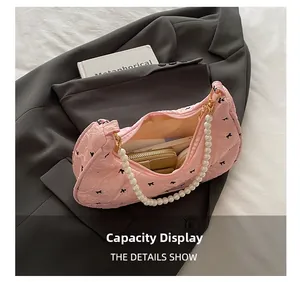 Internal view of pink quilted bow handbag showing storage capacity and pearl strap details