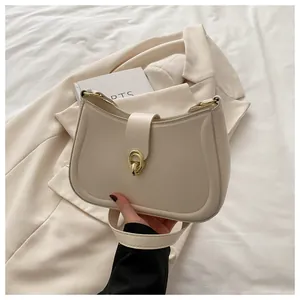 Detailed view of the elegant beige crescent bag with premium gold metal clasp and stitching