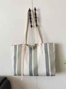 Minimalist large striped canvas tote bag with leather handles and woven texture