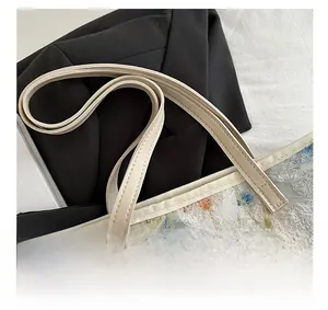 Close-up of beige leather handles and textured floral fabric on a stylish tote bag
