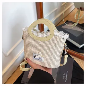 Détail d'un sac en paille crème avec bordure en dentelle, nœud et poignée en cuir
