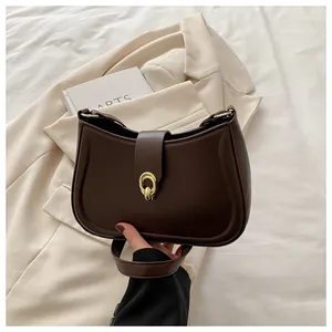 Detailed shot of dark coffee half-moon bag on beige blazer with vintage gold clasp
