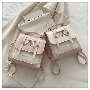Detail of color-block backpack showing bow decor, metal heart charm and fashion print