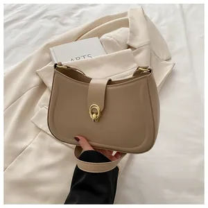 Close-up of golden ring buckle and matte khaki leather texture on half-moon bag