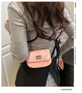 Detail of pink quilted mini crossbody bag with silver clasp and metal chain on model