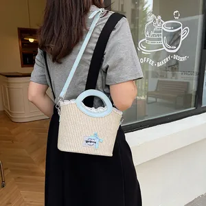 Summer straw tote bag with light blue leather handles and white lace trim detail