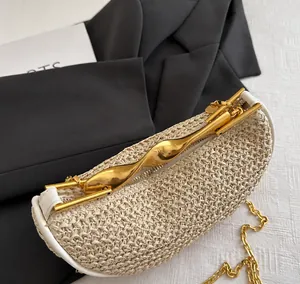 Detail van geweven handtas met artistiek goudkleurig metalen handvat en ketting
