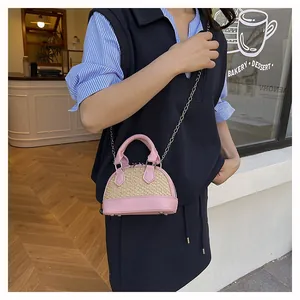 Mini shell-shaped pink leather and straw bag with metal chain strap and base studs