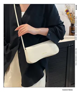 Détail du sac à bandoulière en cuir grainé blanc cassé avec lettrage doré chic