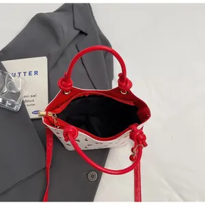Vue détaillée de dessus du sac seau imprimé cerises avec anses rouges et poche interne