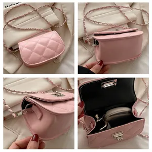 Detail of pink quilted mini crossbody bag showing chain strap and silver lock closure