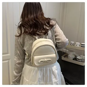 Detail view of mini cream white backpack with bow decoration and adjustable straps