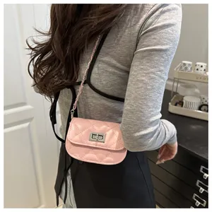 Detail of pink quilted mini crossbody bag with silver rotating lock and chain strap