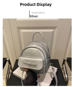 Detail of silver mini backpack featuring a metallic finish and bow accent on front pocket