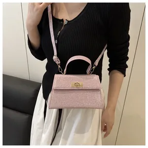 Details der rosa Glitzer-Minitasche mit goldenem Drehverschluss und Schulterriemen