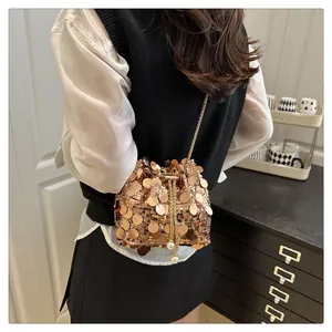 Detail of rose gold sequin bucket bag with gold chain strap and pearl drawstring charms