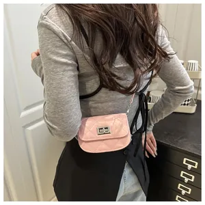 Detail of pink quilted micro crossbody bag with silver twist lock on model side view