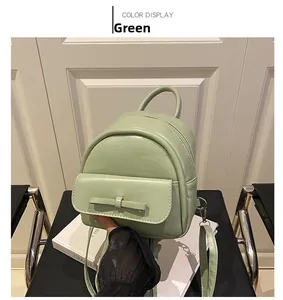 Detail view of mini green backpack featuring a bow-knot pocket and smooth leather finish