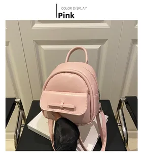 Detail of pink mini backpack with cute bow decoration and textured leather finish