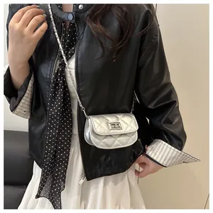 Silver quilted mini crossbody bag with metal chain strap and twist-lock on a model