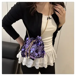 Detail of purple sequin bucket bag featuring gold chain and pearl drawstring charms