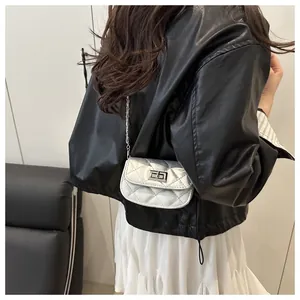 Silver quilted mini square bag with metallic finish and chain strap worn by a model