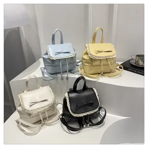 Sacs à dos avec bordure en dentelle et nœud en bleu, jaune, blanc et noir sur socle