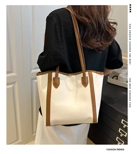 Close-up of contrast color tote bag showing cream body and brown shoulder strap detail