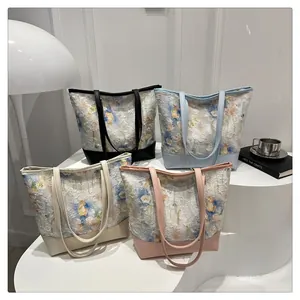 Macro shot of four floral jacquard tote bags in black, blue, beige and pink colors