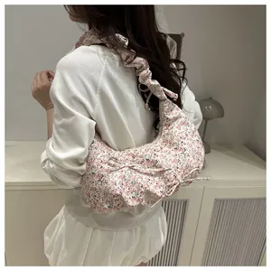 Gros plan du sac hobo à fleurs avec bandoulière plissée et nœud décoratif