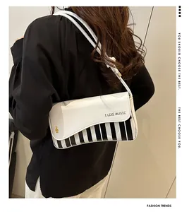 Detail view of the piano key pattern on the black and white faux leather crossbody bag