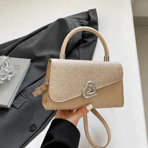 Detail of elegant sequin handbag with a heart-shaped metal buckle and premium texture