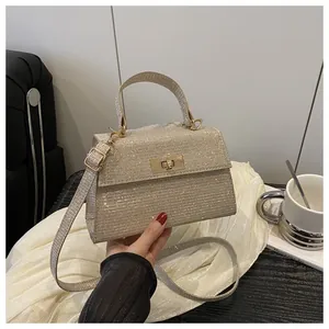 Detailaufnahme der champagnergoldenen Pailletten-Handtasche mit elegantem Metall-Drehverschluss