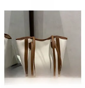 Detail showing two-tone white and brown synthetic leather tote bag with long straps