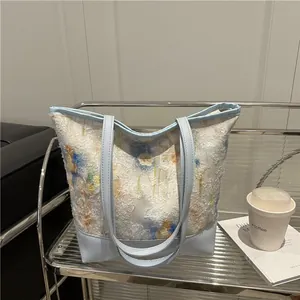 Floral print tote bag with light blue leather straps and spacious open interior design
