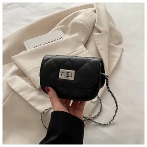 Detail of black quilted mini bag featuring silver twist lock and chain leather strap