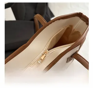 Close-up of contrast color tote bag showing smooth metal zipper and premium inner lining