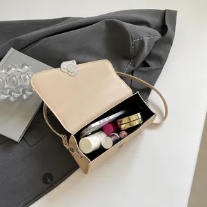Internal capacity of beige sequin square bag showing phone and cosmetics fit