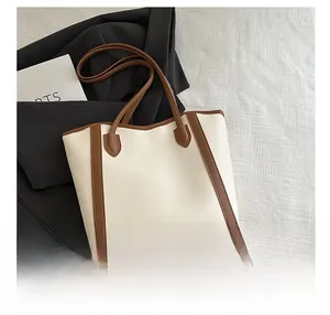 Detail shot showing a smartphone next to the tote bag to demonstrate its large capacity